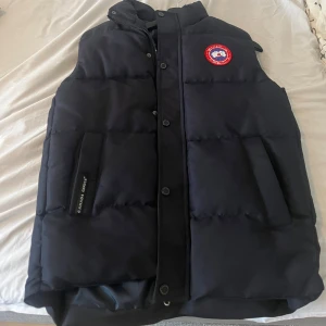 Svart dunväst från Canada Goose - Säljer en stilren svart dunväst från Canada Goose.Perfekt för kyliga dagar knappt använd 