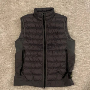 Grå stone Island väst - Jag säljer min gråa stone Island väst som är i nytt skick. Den är lite använd men ser väldigt bra ut och inga skador finns. Hör gärna av er om ni har några eller funderingar hör gärna av er.