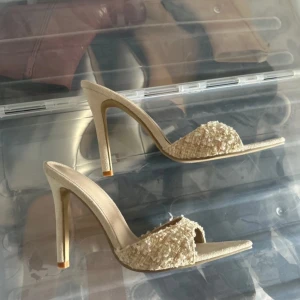 Beige klackskor med textur - Eleganta beige klackskor med en unik texturerad ovandel. Skorna har en spetsig tå och en hög klack som ger en stilren look. Perfekta för att lyfta vilken outfit som helst.
