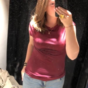 Vinröd topp - Säljer en vinröd topp med rund hals och ärmlös design. Perfekt för en stilren och enkel look. Passar bra till både jeans och kjol.