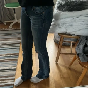 Blå jeans från H&M - Snygga blå jeans från H&M. Gjort ett eget hål på knät. För stor i midjan så använder ej längre.28/32