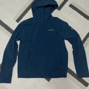 Blå jacka med luva från Peak Performance - Säljer en snygg blå jacka med luva från Peak Performance. 