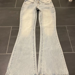 Lågmidjade bootcut jeans - Fina ljusblå lågmidjade bootcut jeans. Midja 37cm innerbenslängd ca 85cm. 