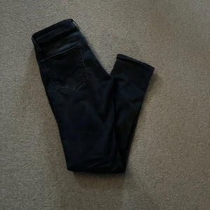 Svartgråa jeans från Jack and Jones - Snygga svartgråa jeansbyxor med en klassisk design. De har en slim passform och är perfekta för en stilren look. Midjemåttet är w28 och L30. Skriv för mer frågor eller bilder😊