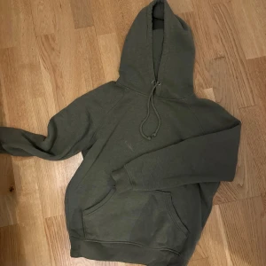 Militärgrön hoodie - Militärgrön hoodie från Bik Bok, tyvärr en liten fläck på tröjan. Storlek XS