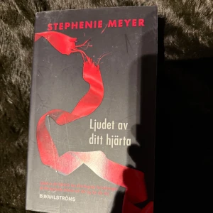 Ljudet av ditt hjärta - Boken 'Ljudet av ditt hjärta' av Stephenie Meyer, utgiven av B. Wahlströms. Omslaget är svart med en röd reva och text i rött och vitt. Perfekt för fans av romantiska och spännande berättelser.