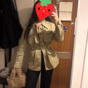 Snygg beige jacka med bälte i midjan och knappar framtill, sitter figursytt. Knappt använd 