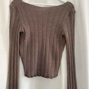 Långärmad topp NAKD - Superfin blus/topp feån NA-KD med lite öppen rygg. Den är glittrig i tyget och är i superbra skick! 