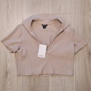 Oanvänd kortärmad beige crop top från Monki. 🤎