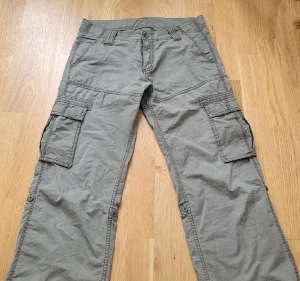 Lågmidjade cargos - Ett par grå-gröna fina lågmidjade cargos från sOlives. Köpt här från Plick men passade tyvärr inte❤️  skriv gärna frågor!    Midjemått (höftmått eftersom de är lågmidjade): 80-82cm Innerbenslängd: 79cm❤️