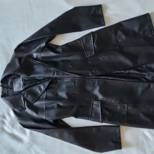 Fuskläder trench  - Fuskläder trench coat från Vero Moda. Dubbelknäppt, 2 fickor. 