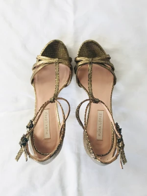 Sandaletter, Pura López, 37  - Sandaletter från Pura López i guld. Superfina detaljer. Storlek 37. Skickas i originalkartongen. Nypris, 1.898kr