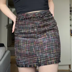 Svart kjol med mönster och fransar.  Vet inte vilken storlek, men skulle säga M eller S