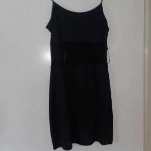 Svart klänning - Svart klänning, genomskinlig i midjan.  Sparsamt använd. 