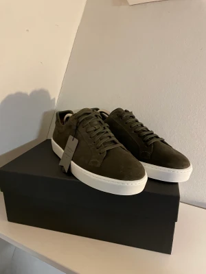 Stockholm design Group  - Ett par Stockholm design Group skor med grön mocka i storlek 43 och aldrig använda prislappen sitter t.o.m kvar på skorna och kartongen.