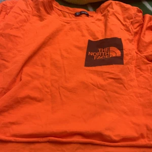 The north face - Orange T-shirt i storlek L. Använd några gånger. Jag är 165cm och för mig är den lite kort i magen.