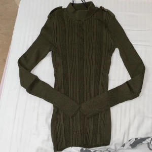 Armé grön fintröja - En tröja som är i storlek S men passar även de som har storlek XS. Är fin till allt och passar till alla tillfällen. Har en knapp på varsin sida på axlarna. Köparen står för frakten ❤️