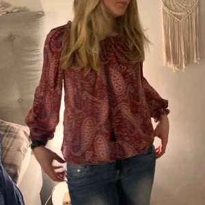 Röd blus - Denna röda blus är ursnygg Färgen och mönstret ger en sån bra känsla.  fint skick. Vill man ha den mer öppen och till och med odd shoulder funkar det också då man kan regelera med banden.💕 Skriv privat vid frågor! TRYCK INTE PÅ KÖP NU TACK!