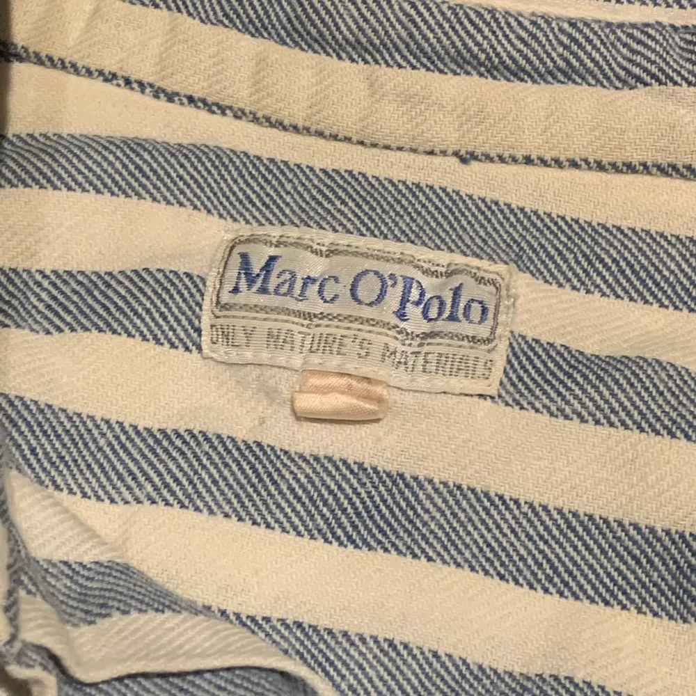 Marc O’Polo-skjorta. Ränder i blått vitt och gult. Mjukt bomullstyg, ärvd från min faster så den är nog från 80-talet. Ändå i väldigt gott skick. Skjortor.