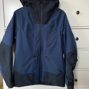 Skidjacka Everest  - Fin fin mörkblå skidjacka i topp skick, knappt använd, perfekt inför sportlovet. Det är en fodrad Everest jacka med många funktioner som snöstopp, luftkonditionering, lifkortsficka m.m. Säljer den då jag har köpt en annan :)
