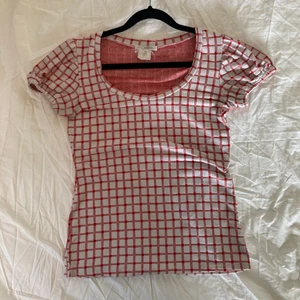 Söt rutig topp - Säljer denna röd- och vitrutiga topp! Den har puffiga ärmar och är i ett stretcihgt material vilket gör att den sitter tight och snyggt! Köpt på Humana och är i jättebra skick☀️ Skriv för fler frågor 