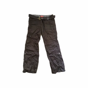 Bruna cargobyxor - Säljer dessa supersnygga cargobyxorna som är från 2000-talet. Säljer pga att de är alldeles för korta på mig:/ köptes secondhand men de är i bra skick. Skärp medföljer! Innerbenslängd: 73cm Midjemått: 88cm