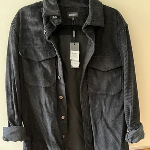 Svart manchesterjacka  - Svart skjortjacka i Manchester, herrmodell strl XL. Köpte pga ville ha den i oversize men inte kommit till användning. Nypris 400 kr, lappar kvar. Köpt på Kings & Queens i Malmö.