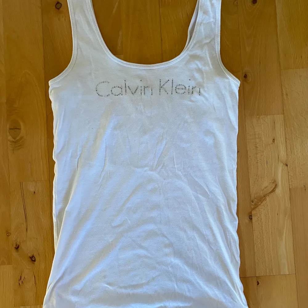 Calvin Klein linne med rhinestones, endast en minimal fläck på framsidan som knappt syns. Toppar.