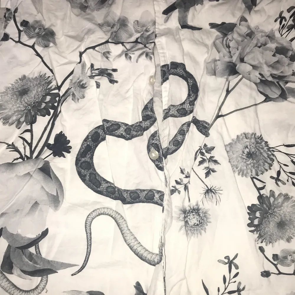 Skjorta med mönster av orm och blommor . Skjortor.