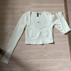 H&M Topp - Superfin topp med fina detaljer runt bröstkorgen.
