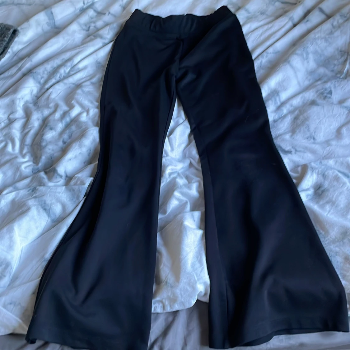 Svarta utsvängda byxor