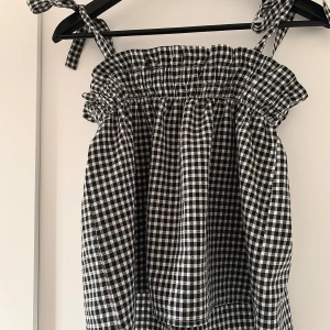 Rutigt linne  - Ett svart/vitt rutigt linne från H&M I strl XS💕 Jätte bra skick och använt cirka 3 gånger. Säljer då det inte är min stil längre. Går att ljustera banden. Kan skicka och möta upp i Örebro. Köparen står för frakten💞