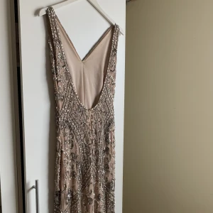 Balklänning/ festklänning med paljetter och stenar  - Festklänning/ balklänning med öppen rygg. Hela klänningen har detaljer med stenar och paljetter. Klänningen har även släp! Skickar bilder med klänningen på vid förfrågan💕 Pris går att diskutera