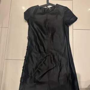 Oanvänd klänning i skinnimitation i storlek XS