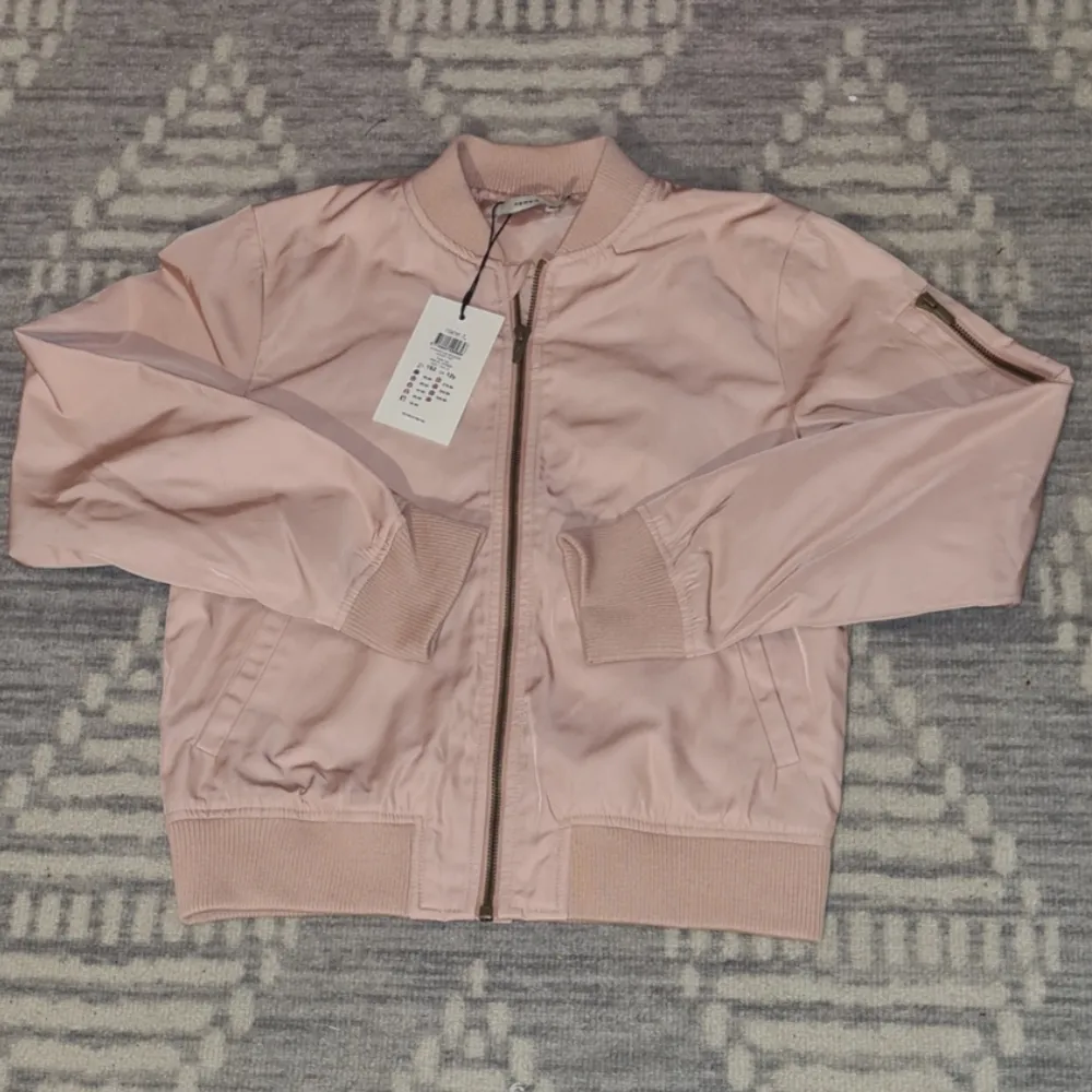 Helt oanvänd pärl-rosa jacka, med prislappar kvar. Skönt, tåligt och bra material. (Från början köpt för 450 kr). Köp via Swish. . Jackor.