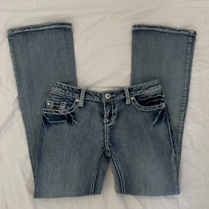 Lågmidjade jeans - !Säljer fler jeans!Midja:72 innerben:71 går inte att få bild på då de är för små🫶liknar true religion jeans med vita kontrastsömmar😽 (obs! Har en fläck på ena låret, syns på första bilden) ANVÄND KÖP NU