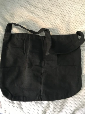 Svart axelväska - En helt ny svart axelväska! Jag råkade köpa två stycken och behöver egentligen bara en så tänkte att jag kanske kan sälja andra här! Skit smart och funkar ti det mesta! Har en ficka på insidan! Och även knäppe! 