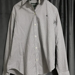 Ralph Lauren skjorta - Herr Ralph Lauren skjorta i ett smått rutigt mönster. Färgen är vit och marinblå. Skjortan är i bra skick och är bara använd en gång. Storlek S. Pris kan diskuteras. Köparen står för frakten. Betalning sker via Swish.