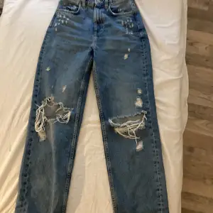 mörkblå jeans med hål från H&M storlek 34 theme: 90’s straight  original pris: 299 tror jag