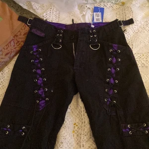 cargobyxor poizen - cargobyxor från poizen industries! aldrig använda köpte från sellpy. Byxorna har snörningar och lila detaljer med dragkedja vid benen. det är lila söm. Hör av dig om fler bilder:)