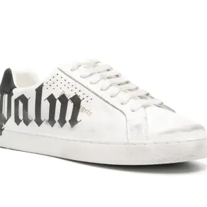 Palm Angels låga sneakers är prydda med märkets logotyp i gotisk stil på sidorna. De överdimensionerade svarta bokstäverna poppar mot det vita lädret.  Höjdpunkter vit kalvskinn bedrövad effekt perforerade  logotyptryck på sidan platt gummisula, Logotyp