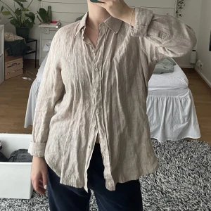 Beige linneskjorta - Linneskjorta från Gina Tricot. Matchar linnebyxorna som finns längre ner i mitt flöde. Jättefin skjorta som användes en del förra våren men som inte riktigt är min stil längre. Köparen står för frakt. 