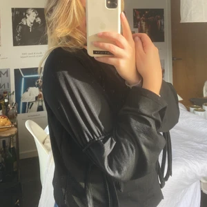 Långärmad svart tröja med detaljer - En fin kvälls/fest tröja med fina knytning runt ärmarna