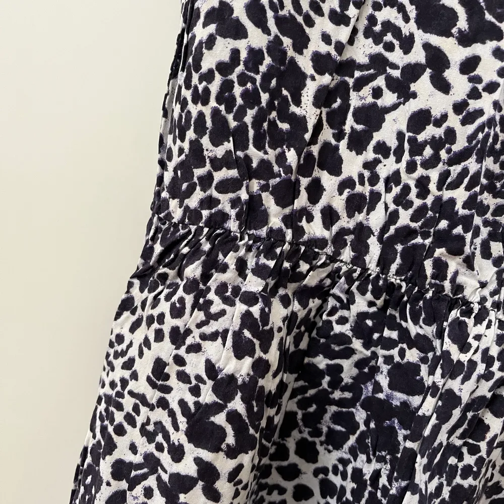 Leopardmönstrad klänning i vitt och mörkblått. U-ringad och med tunnt resor i midjan. . Klänningar.