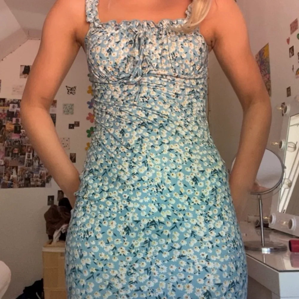 En enkel blommig blå tajt klänning!an får otroligt fina former, materialet är väldigt skönt och det är en kort modell.Tyxker om den här, men den kommer inte till användning . Klänningar.