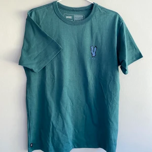  T-shirt med tryck på ryggen - Vans - (Tryck inte ”köp nu” skriv istället till oss) Blå/grön T-shirt med tryck på ryggen. Änvänd 1 gång. Frakten står du för själv💕