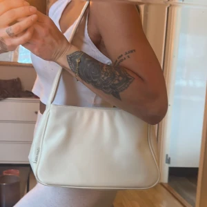 Vit väska  - Vit classic väska, man får plats med mycket i den.