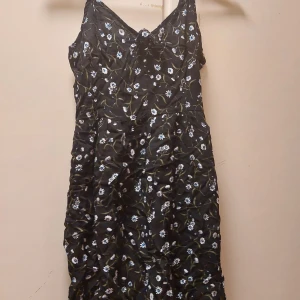 H&M, S - Svart blommig klänning i st S, aldrig använd. Den är i bra skick. Den är över knäna, ca i mitten av låret.  60kr+frakt