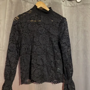 Svart spets tröja - En svart tröja i spets från Nelly. Är bara använd några gånger. 