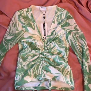 Topp - Super fin topp i grönt och vitt! Snörning i mitten så att den går att anpassa efter hur du vill ha den! Aldrig använd och lappen kvar